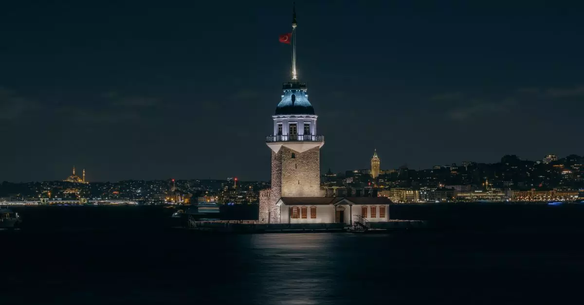 A serene night view of the illuminated Maiden's Tower against Istanbul's skyline.