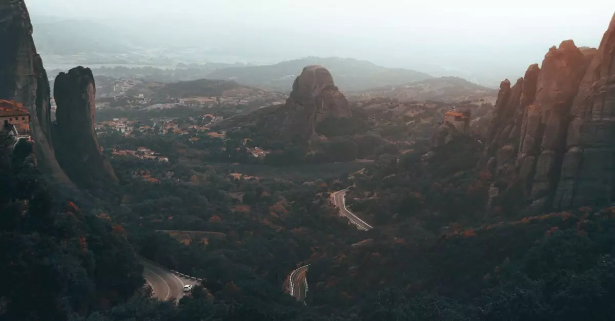 A breathtaking aerial view of the Meteora rock formations, with winding roads and misty landscapes in Greece.