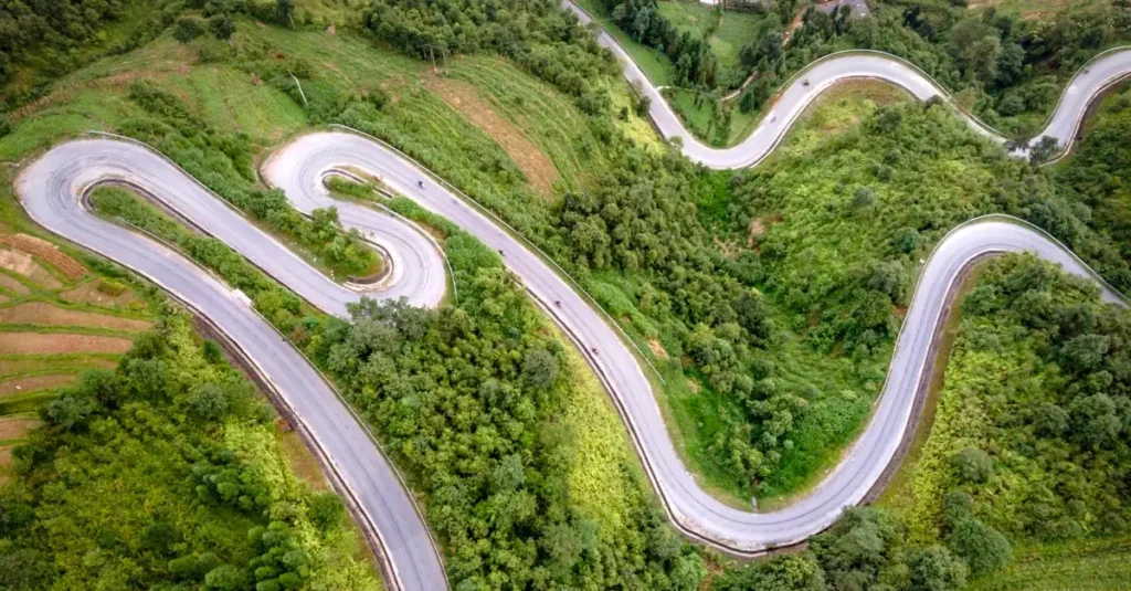 Best Scenic Road Trips in the World: South America 11 Aerial view of a winding mountain road amidst lush green nature, perfect for adventurous travels.