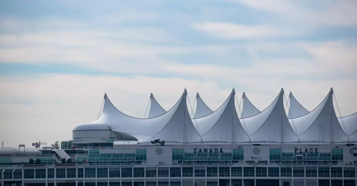 Iconic Canada Place building with its sail-like roof in Vancouver, BC against a blue sky.