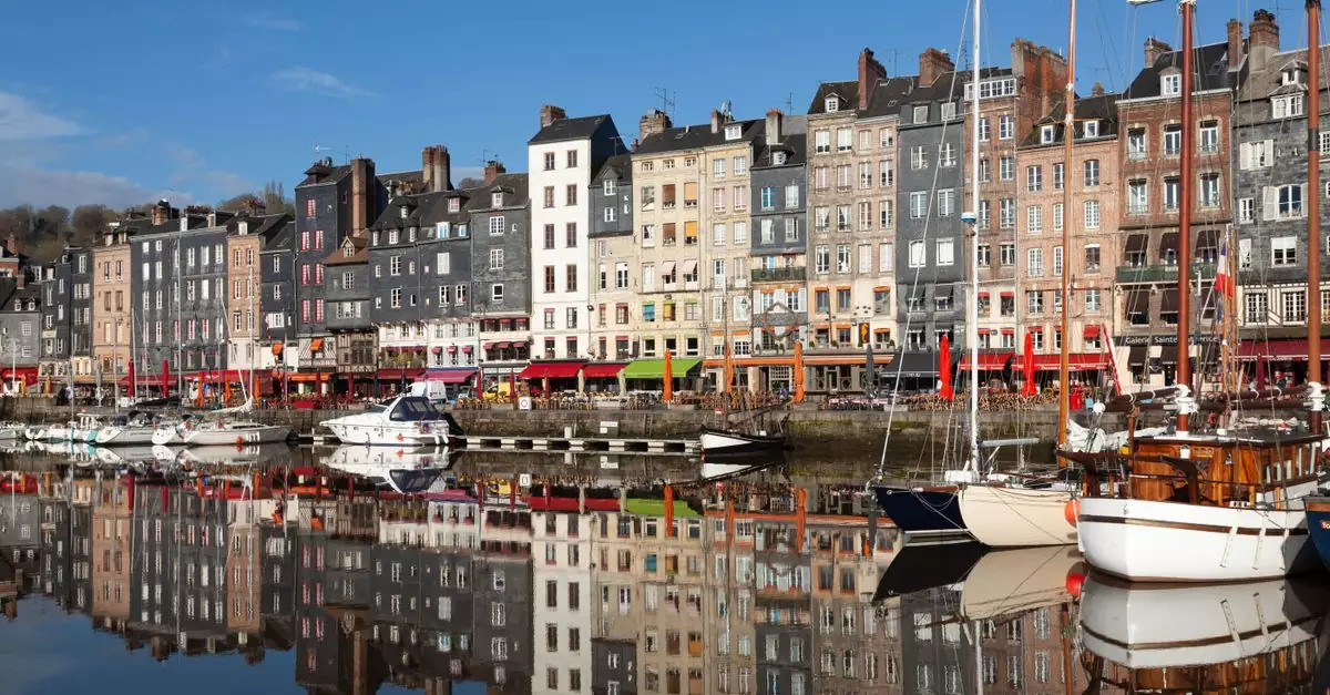 Charming view of Honfleur harbor with colorful buildings and boats reflecting on the water.