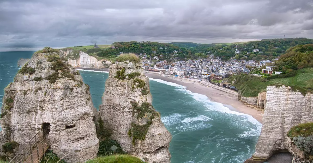 Breathtaking view of Étretat's white cliffs and coastal town in Normandy, France.