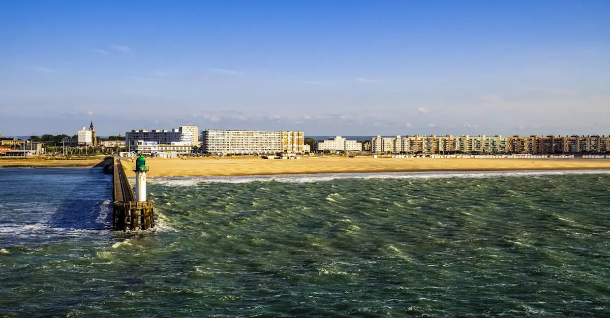 Vibrant seaside view of Calais, France with pier, sandy beach, and cityscape.