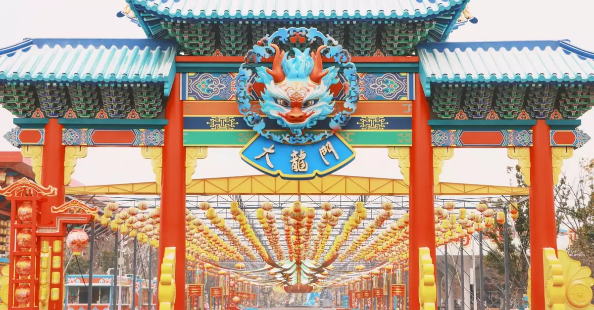 Colorful traditional Chinese dragon gate adorned with lanterns during daylight.