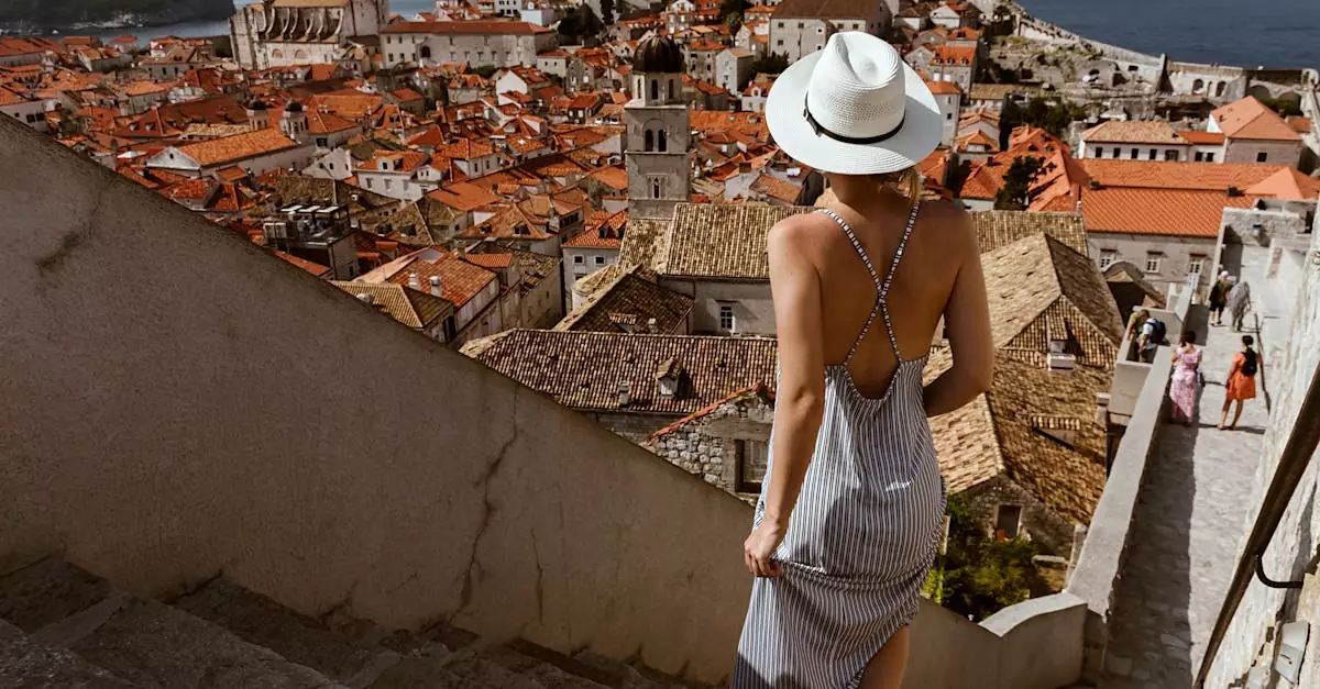 Woman in a summer dress and hat enjoys Dubrovnik's ancient cityscape and sea view.