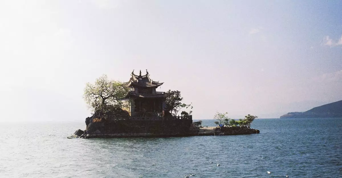 Isolated traditional temple on a small island surrounded by calm sea at dusk.