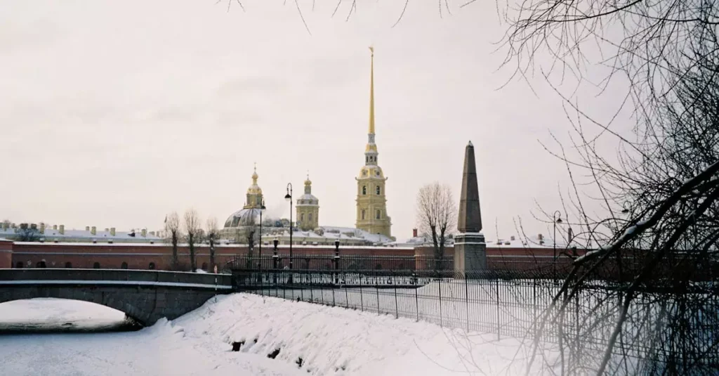 Scenic winter view of the Peter and Paul Fortress with snow covering and icy river.