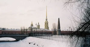 Scenic winter view of the Peter and Paul Fortress with snow covering and icy river.
