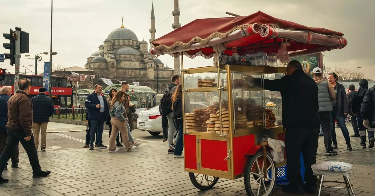 Street food vendor cart in Istanbul with mosque in background, showcasing local culture.
