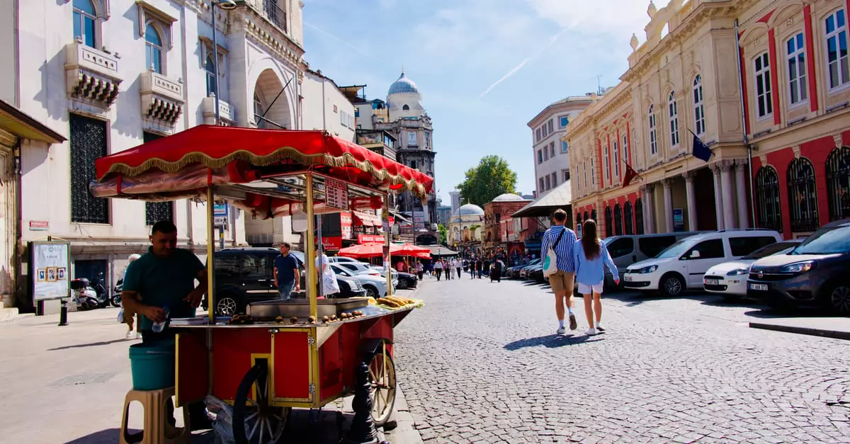 A vibrant street scene in Istanbul featuring a vendor with a classic red food cart.
