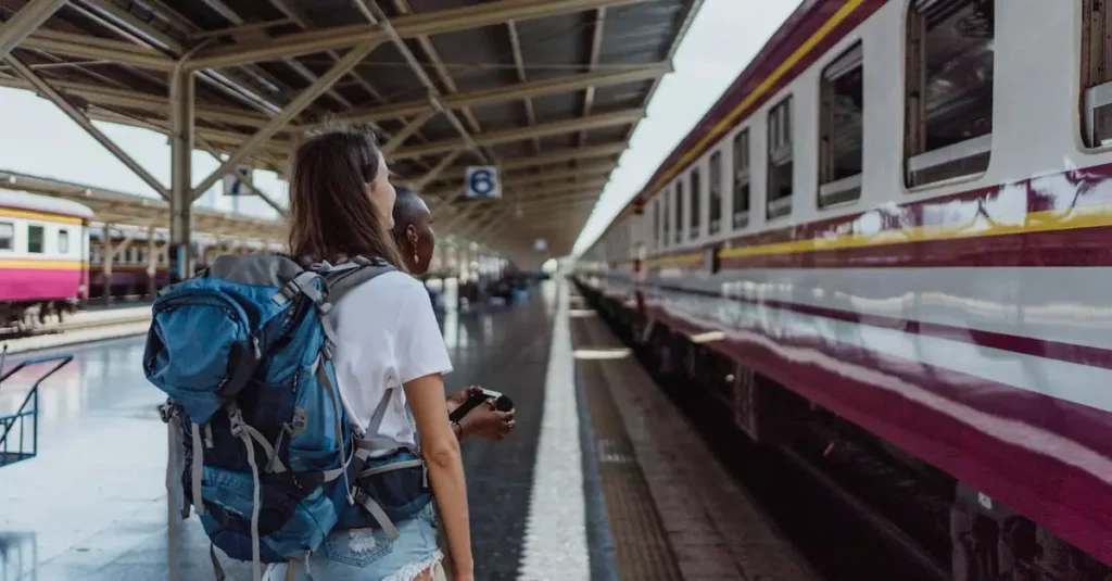 Best Train Routes for Couples in Europe 2 Two women with backpacks waiting at a railway station for a train. Travel and adventure theme.