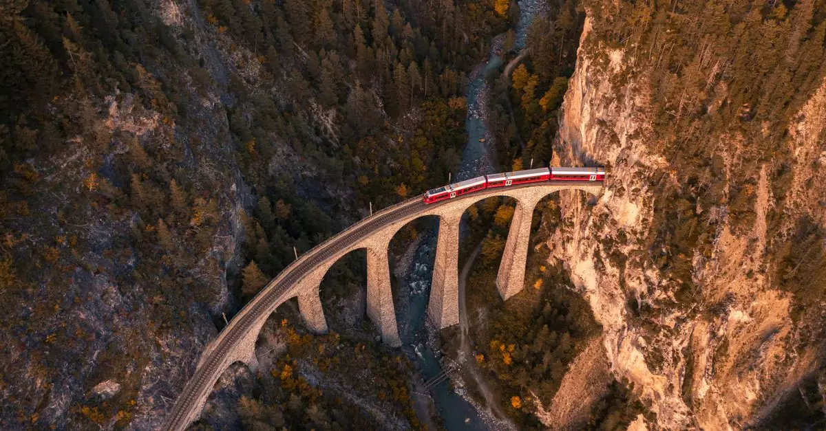Drone shot of a train crossing the iconic Landwasser Viaduct in Switzerland.
