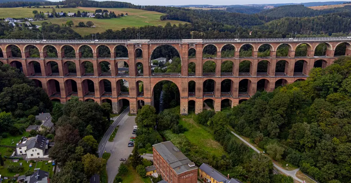 Aerial view of the iconic Göltzschtal Viaduct surrounded by lush greenery in Netzschkau, Saxony.