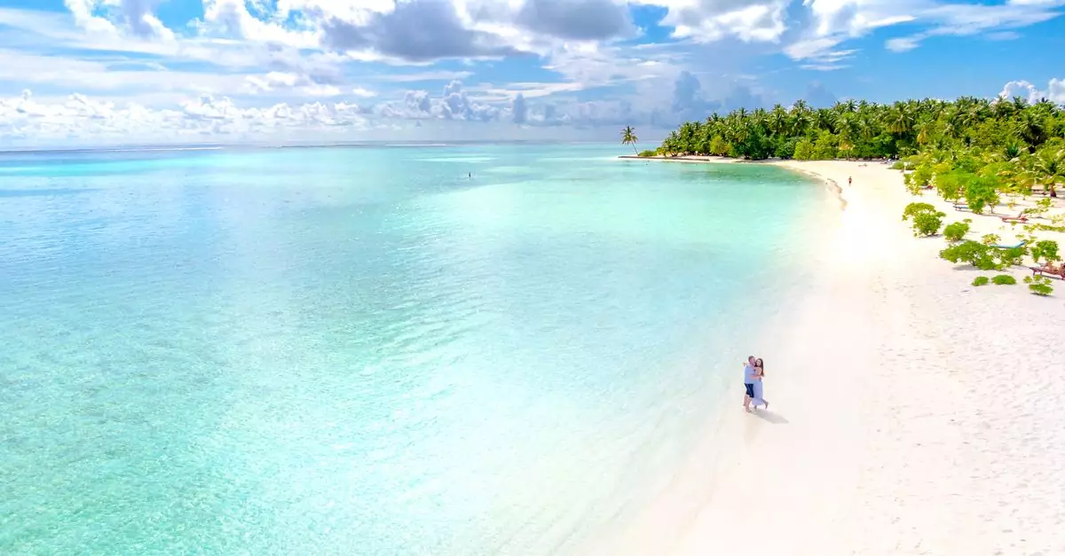 Couple enjoying a romantic moment on a pristine tropical beach in the Maldives.