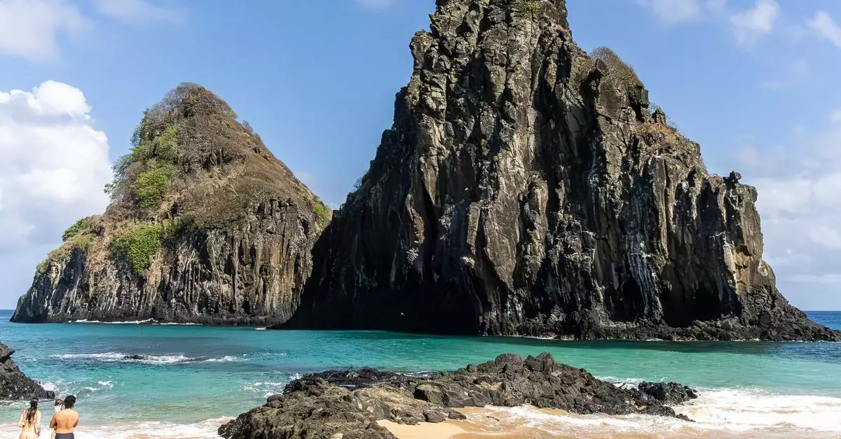 Scenic view of Two Brothers Rock from a sandy beach in Fernando de Noronha, Brazil.