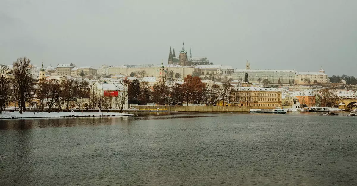 Scenic winter view of Prague Castle across the river with a snowy landscape.
