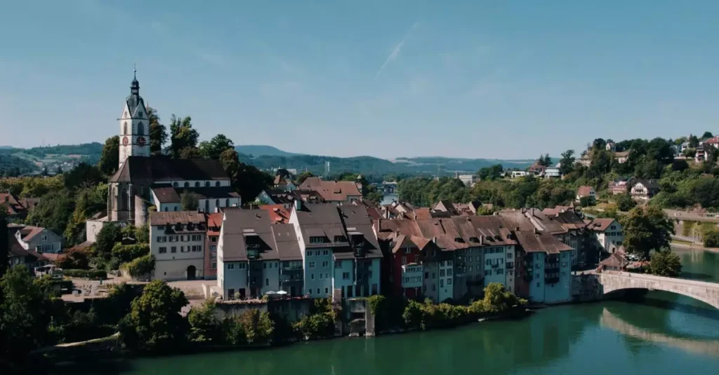 Aerial view of historic Laufenburg, Switzerland, featuring architectural charm along the Rhine River under a clear summer sky.