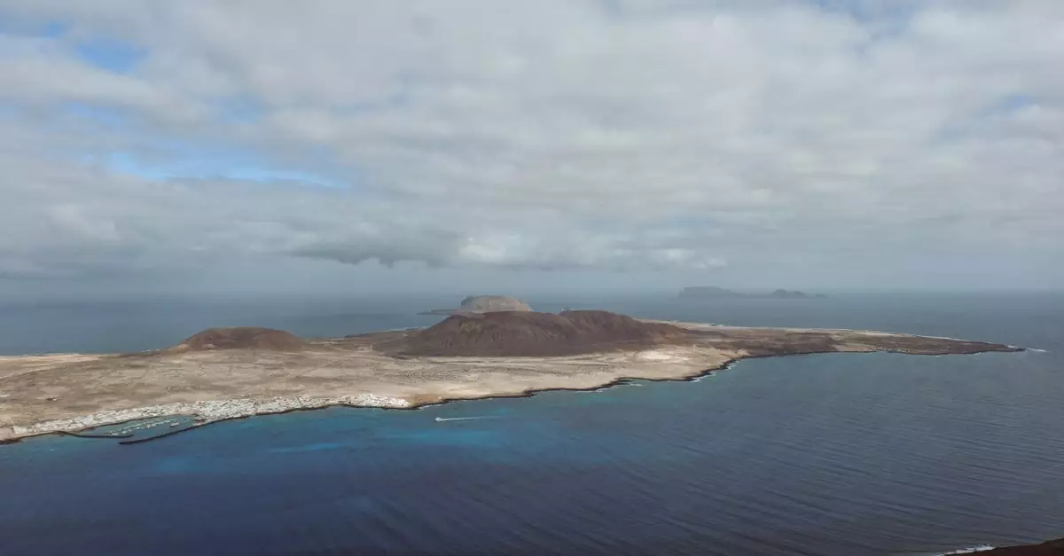 Breathtaking aerial view of La Graciosa Island with ocean and dramatic clouds, seen from Lanzarote.