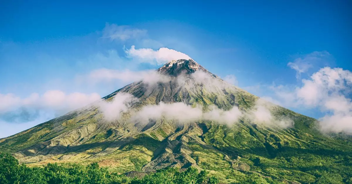 Stunning view of Mayon Volcano surrounded by blue skies and clouds in Bicol, Philippines.