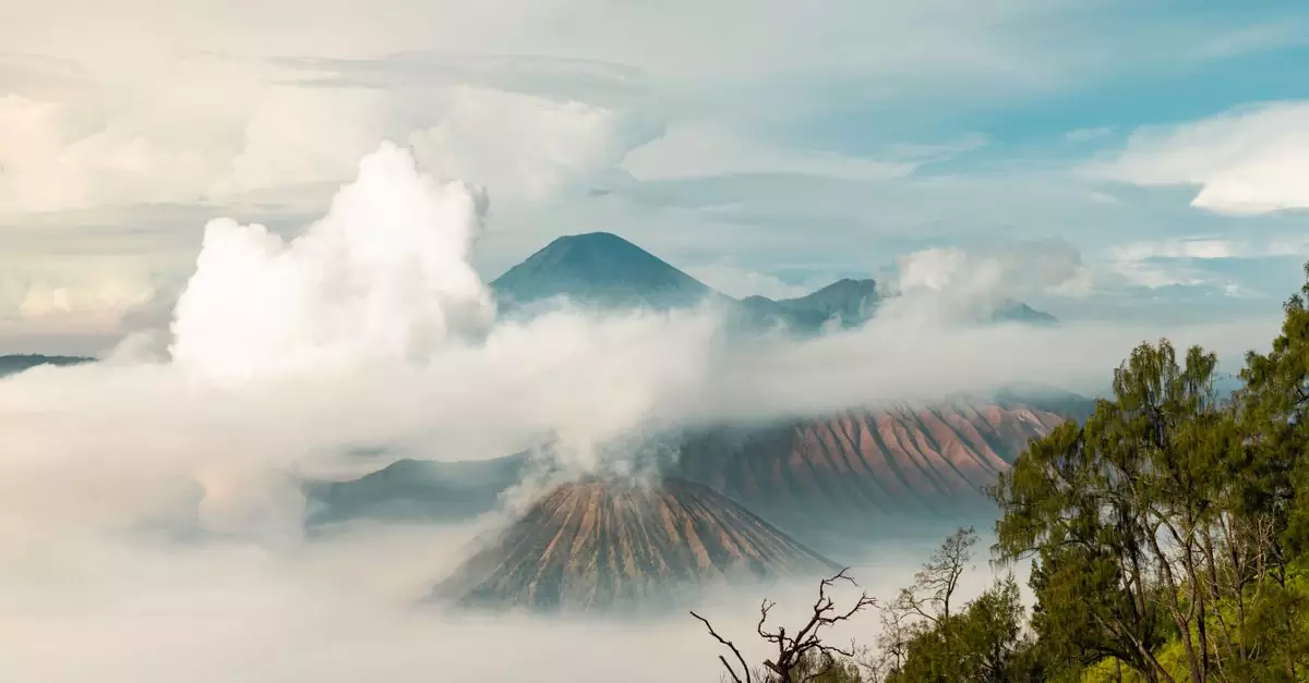 Stunning aerial view of Mount Bromo surrounded by mist and clouds in East Java, Indonesia.