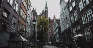 Cobblestone street in Gdańsk, Poland, featuring Gothic architecture and a vibrant urban atmosphere.