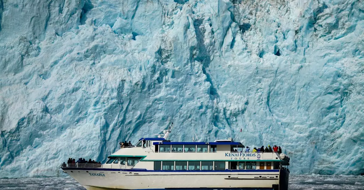 Tour boat navigating near a massive glacier, offering breathtaking views.