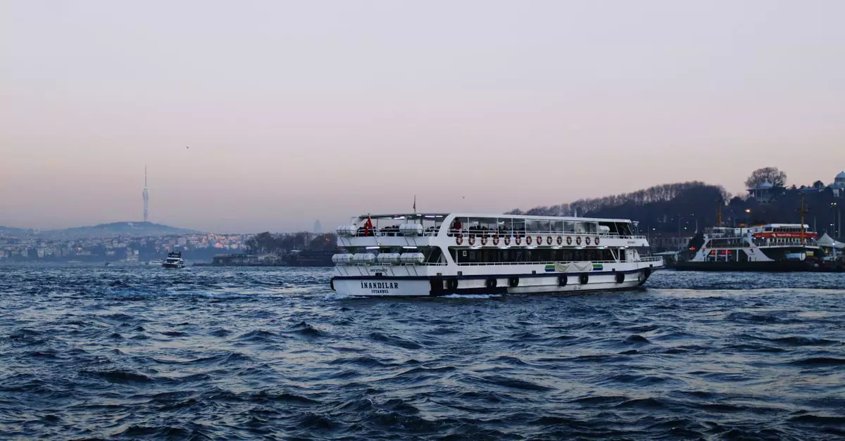 A ferry sails across the Bosphorus in Istanbul, with a cityscape in the background.