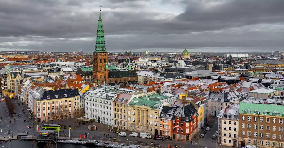 Aerial view of Copenhagen's colorful historic buildings under cloudy skies.