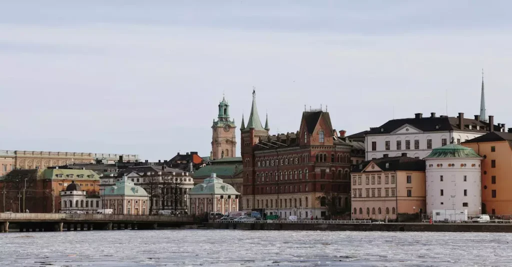 Scenic winter view of historical buildings along Stockholm's waterfront with ice floating on the water.
