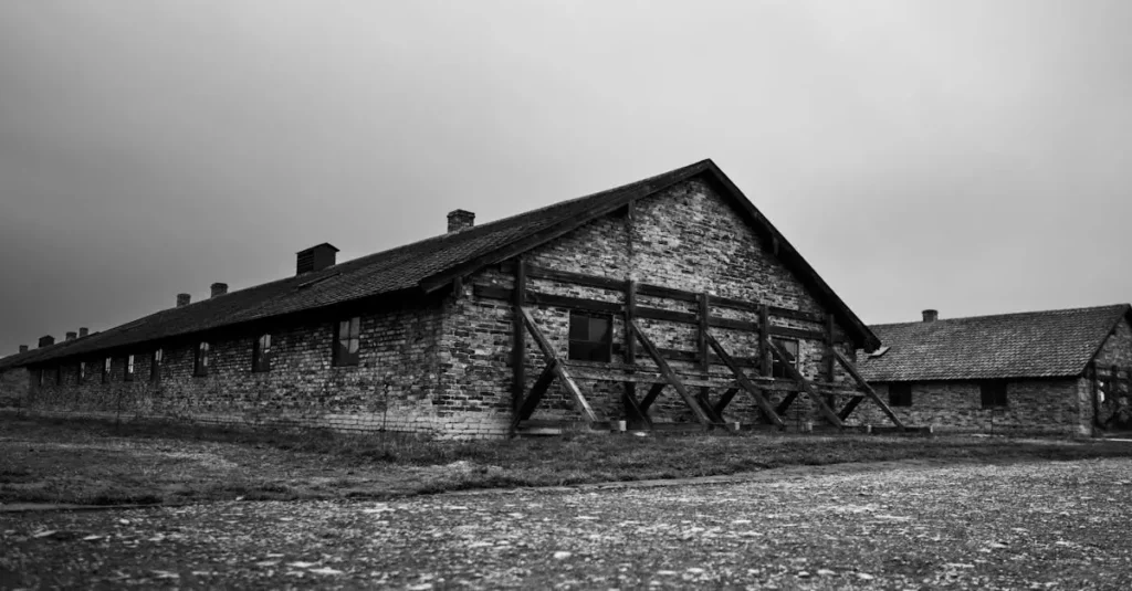 Best WWII Museums in Europe: A Definitive Guide 2 Black and white image of Auschwitz-Birkenau barracks building with cloudy sky.