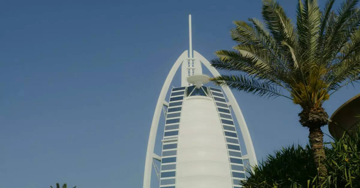 A striking view of the Burj Al Arab against a clear blue sky, framed by palm trees.