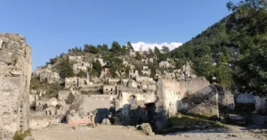Explore the haunting beauty of Kayaköy ruins nestled on a hillside.