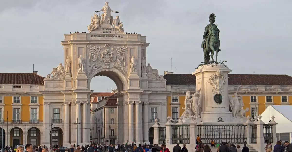 Bustling scene at Pra&ccedil;a do Com&eacute;rcio, Lisbon featuring Arco da Rua Augusta and King Jos&eacute; I statue.