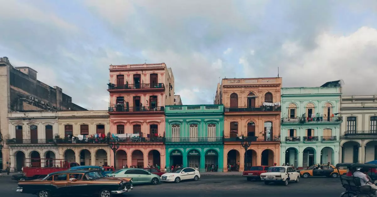 A vibrant street scene depicting colorful colonial buildings and classic cars in Havana, Cuba.