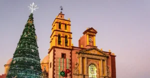 Beautifully decorated Christmas tree beside a historic church in Tequisquiapan, Mexico during sunset.