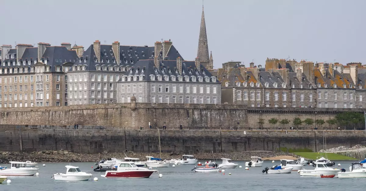 Picturesque view of Saint-Malo's historic buildings and boats along the coastline in Brittany, France.