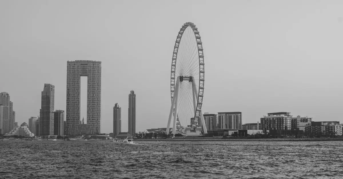 Scenic view of Dubai skyline featuring iconic Ferris wheel and urban architecture in black and white.