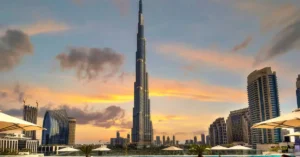 Stunning view of the Burj Khalifa and Dubai skyline from a rooftop pool at sunset.