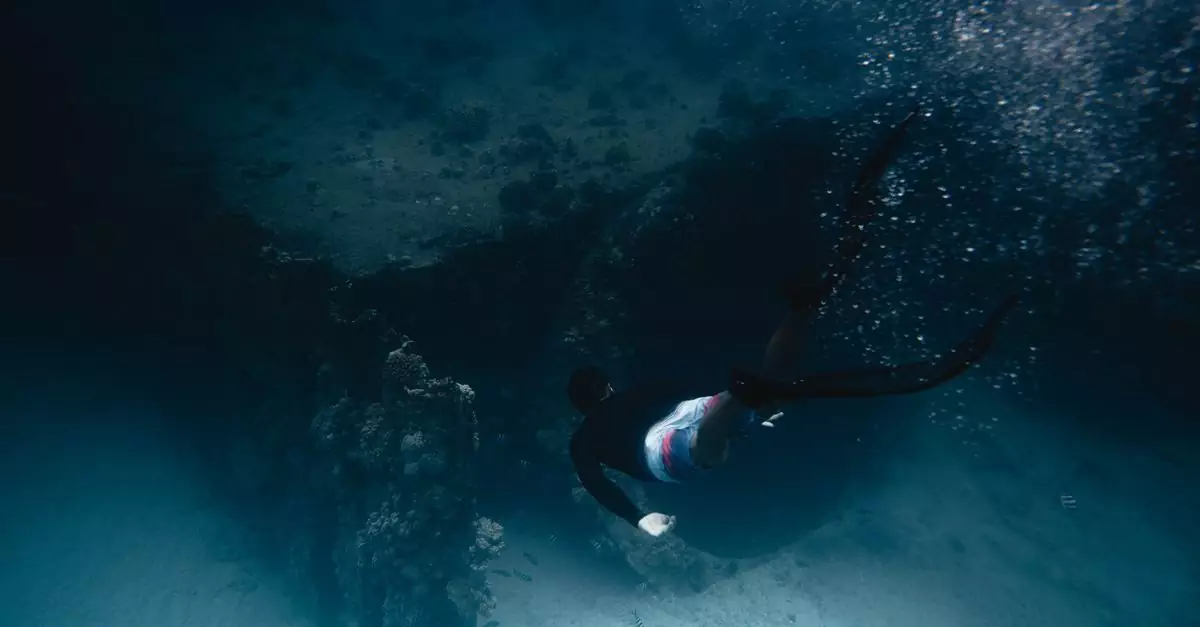A diver swims gracefully through a vibrant coral reef underwater, captured in motion.