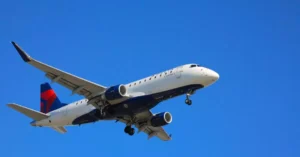 Airplane mid-flight beneath a clear blue sky, showcasing aviation technologies.