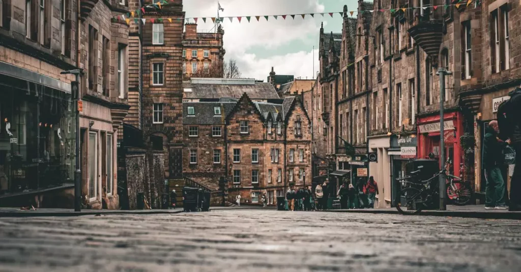 Scenic view of a historic street in Edinburgh, Scotland, featuring traditional architecture and colorful bunting.