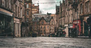 Scenic view of a historic street in Edinburgh, Scotland, featuring traditional architecture and colorful bunting.