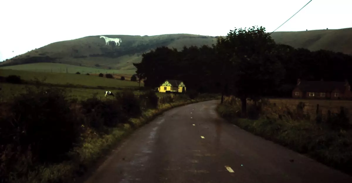A moody countryside road with a view of the Westbury White Horse in England.