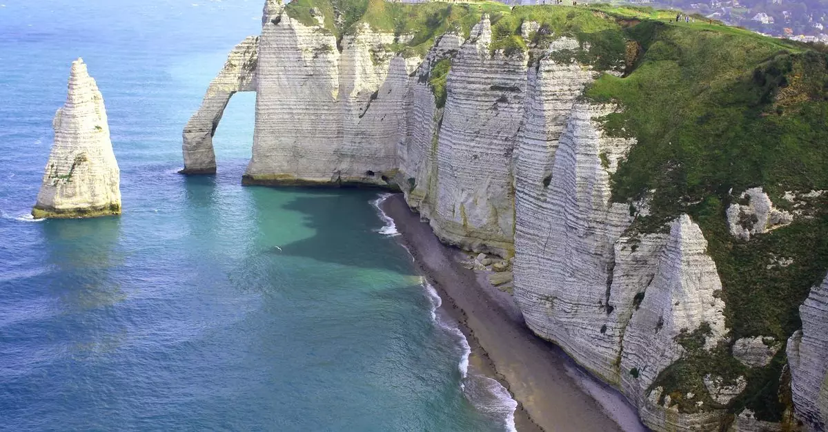 Scenic aerial view of the famous &Eacute;tretat cliffs and beach in Normandy, France. A tranquil seascape with limestone formations.