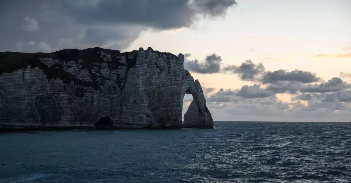 Stunning view of Étretat cliffs in Normandy, France at dusk with dramatic clouds.