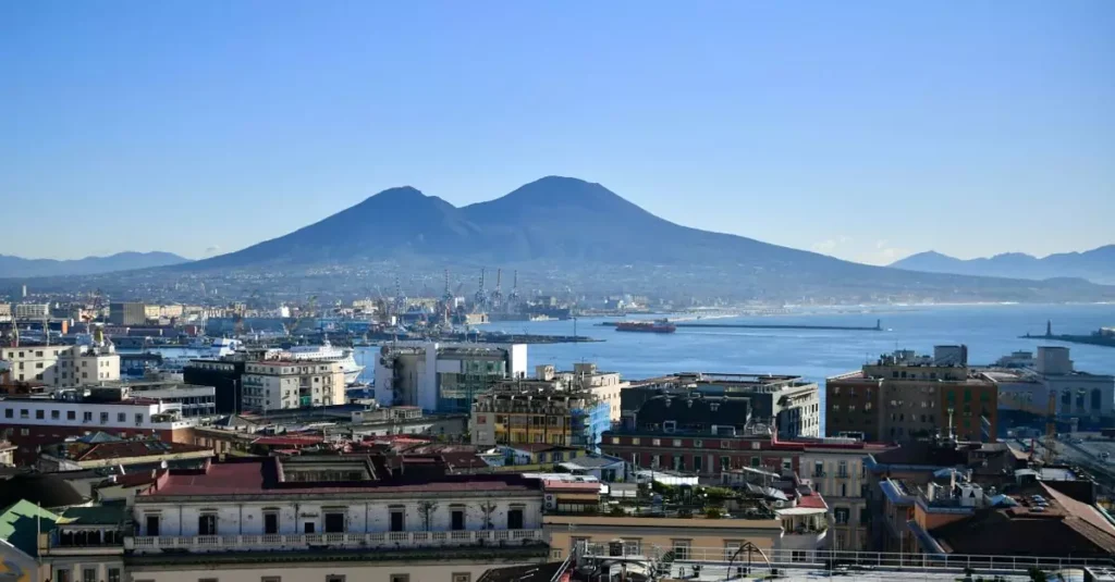 7 Famous Volcanoes You Can Visit: A Global Guide 2 Aerial view of Naples, Italy with Mount Vesuvius in the background, capturing the vibrant coastal cityscape.