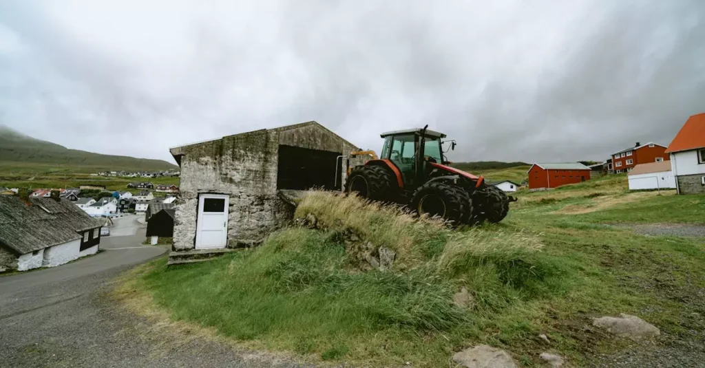Scenic rural view of a Faroe Islands village with a red tractor and traditional architecture.