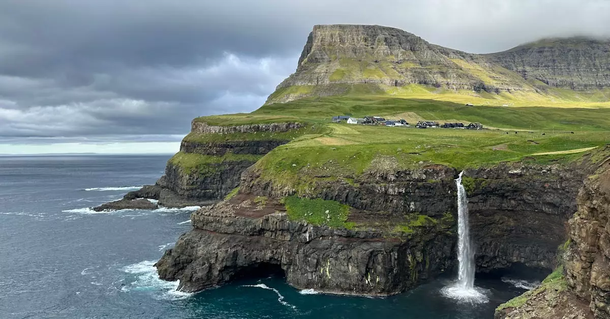 Stunning landscape of cliffs and a waterfall near the ocean in the Faroe Islands.