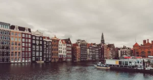 Charming Amsterdam canal and traditional houses with cloudy sky.