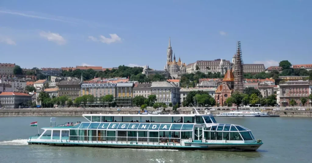 Cruise ship on the Danube with Budapest skyline featuring Fisherman's Bastion and Matthias Church.